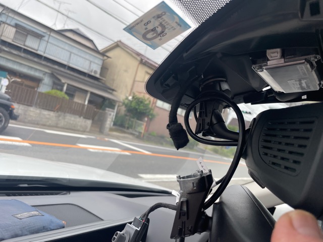 純正ミラーを外していきます。センサーを覆っている黒い大きな黒いカバーは少し硬いですが両サイドにコジると外せます。次にミラーの外し方は車種によりネジ止めだったりサイドからツメを押して回して外して行きますが、今回は回すタイプでした。あとは純正ミラーに差さっているカプラーを外し、音がカタカタしないように布テープを巻いてまとめておきます。<br>